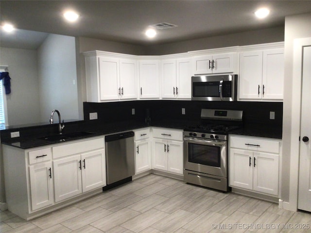 kitchen featuring white cabinetry, appliances with stainless steel finishes, sink, and tasteful backsplash