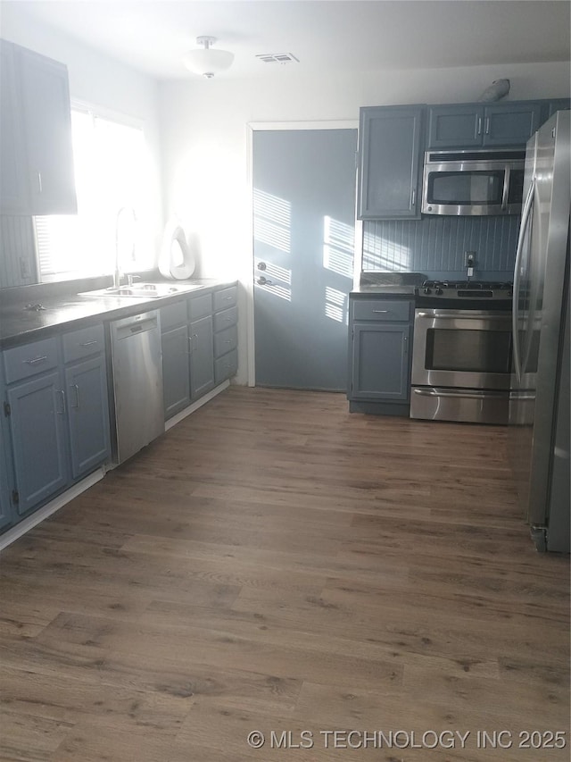 kitchen with stainless steel appliances, sink, dark hardwood / wood-style flooring, and gray cabinets