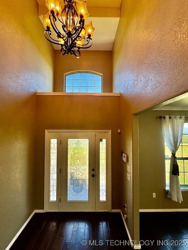 foyer featuring dark wood-type flooring and a chandelier