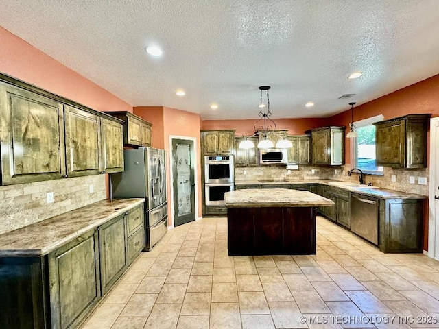 kitchen featuring sink, hanging light fixtures, appliances with stainless steel finishes, a kitchen island, and decorative backsplash