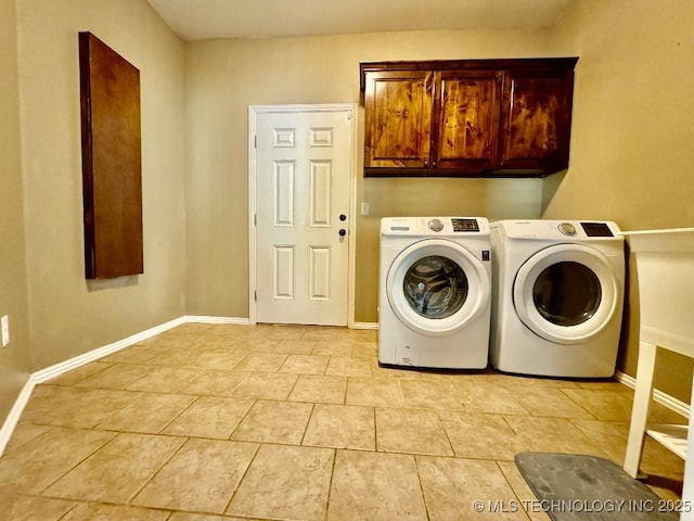 laundry room featuring light tile patterned floors, cabinets, and washing machine and clothes dryer