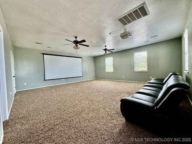 carpeted home theater featuring ceiling fan and a textured ceiling