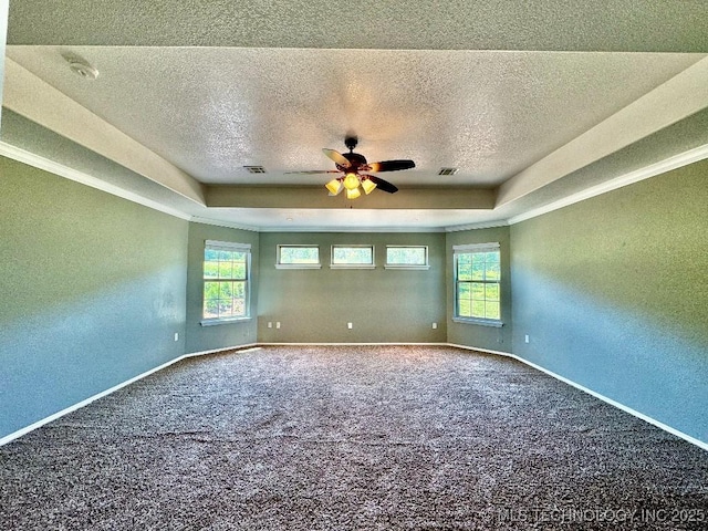 carpeted empty room with ceiling fan, a tray ceiling, and a textured ceiling