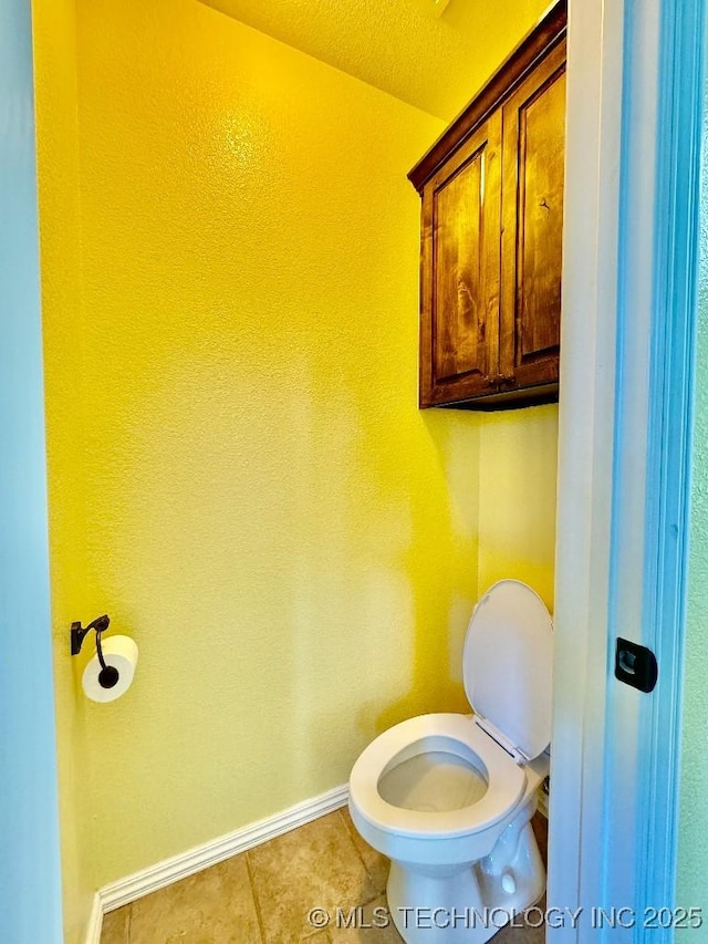 bathroom featuring toilet and tile patterned flooring