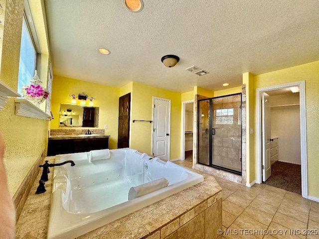 bathroom featuring tile patterned flooring, vanity, shower with separate bathtub, and a textured ceiling