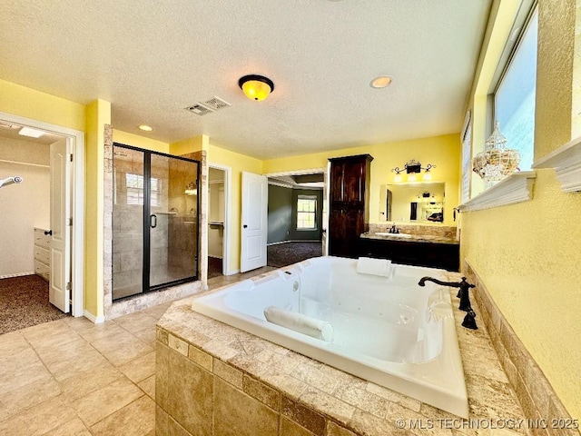 bathroom featuring vanity, a textured ceiling, and separate shower and tub