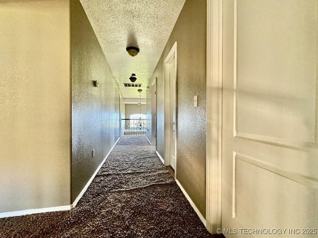 hall featuring a textured ceiling