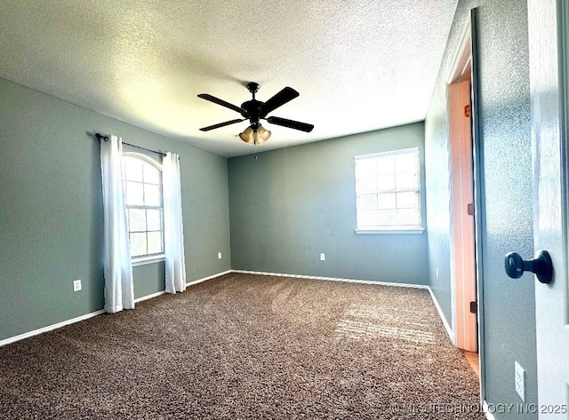 carpeted spare room featuring a textured ceiling and ceiling fan