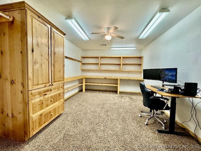 carpeted home office with ceiling fan and a textured ceiling