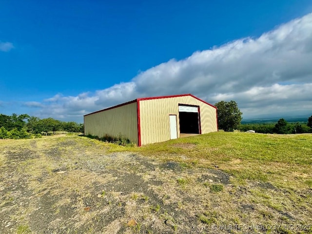 view of outbuilding featuring a lawn and a rural view