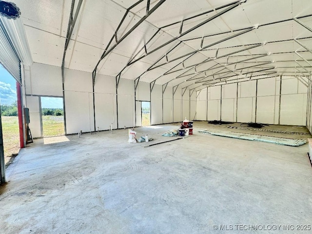 miscellaneous room with concrete flooring and vaulted ceiling