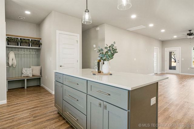 kitchen featuring pendant lighting, hardwood / wood-style floors, a center island, and ceiling fan