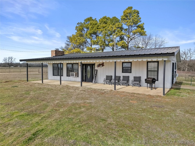 rear view of property with cooling unit, a lawn, and a patio area