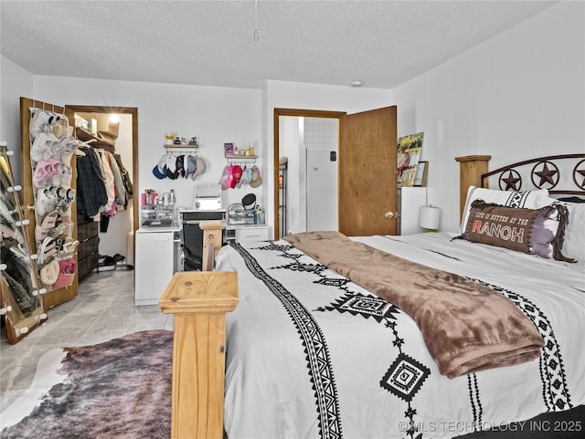 bedroom with a walk in closet, a closet, and a textured ceiling