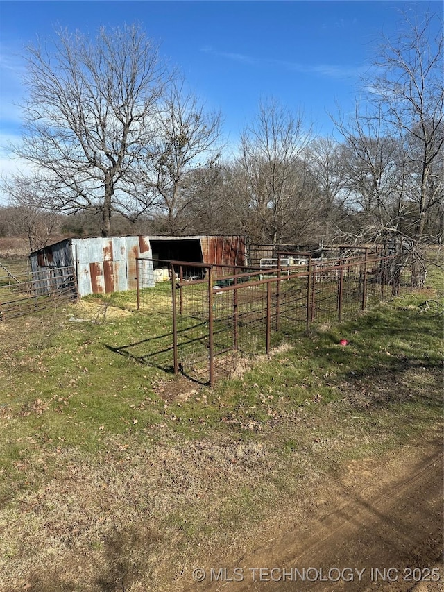 view of yard featuring an outdoor structure and a rural view