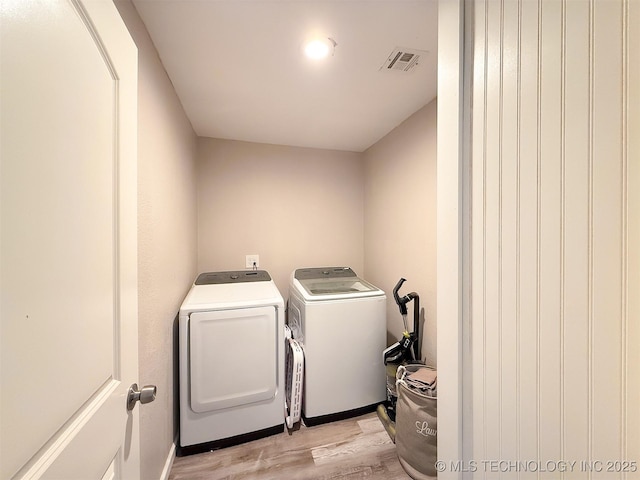 laundry room with washer and dryer and light hardwood / wood-style flooring