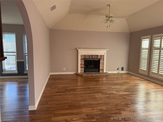 unfurnished living room featuring a fireplace, dark wood-type flooring, ceiling fan, and vaulted ceiling