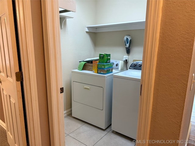 washroom featuring light tile patterned floors and washer and clothes dryer