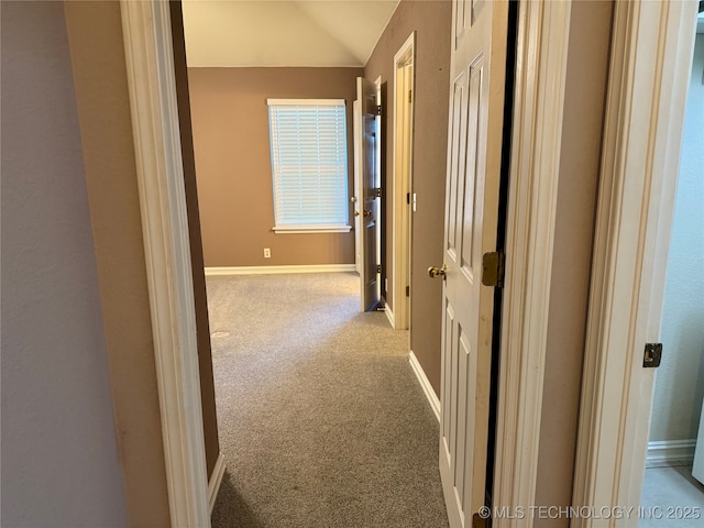 hallway featuring lofted ceiling and light colored carpet