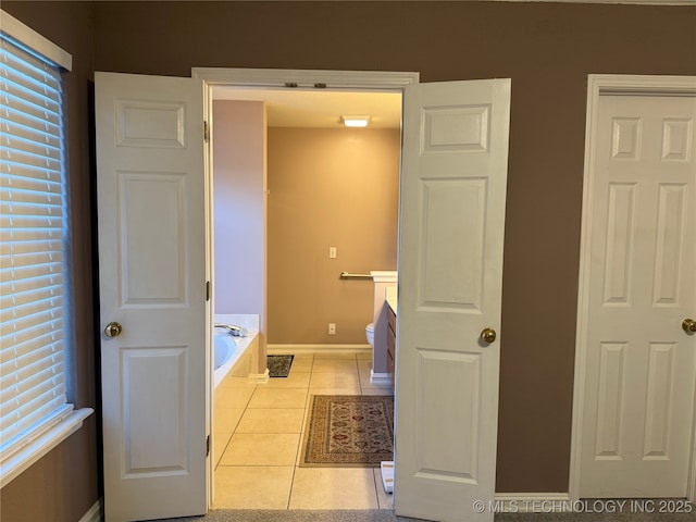 bathroom with vanity, tiled tub, tile patterned floors, and toilet