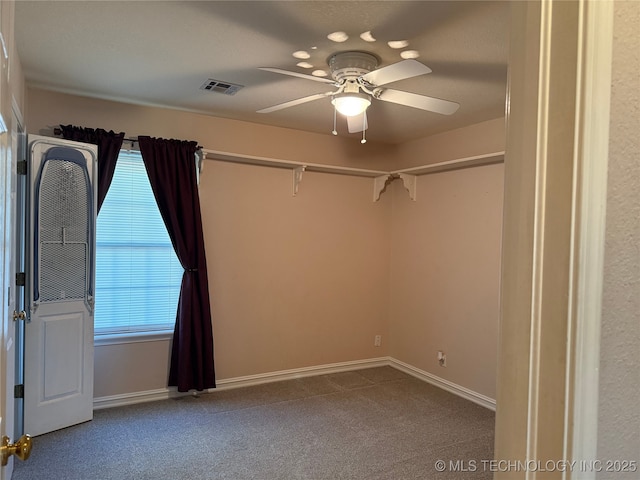 spare room featuring ceiling fan and carpet floors