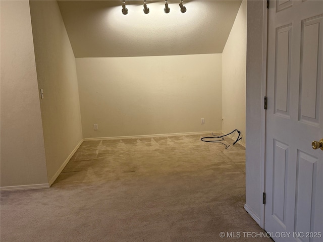 bonus room with vaulted ceiling and light colored carpet