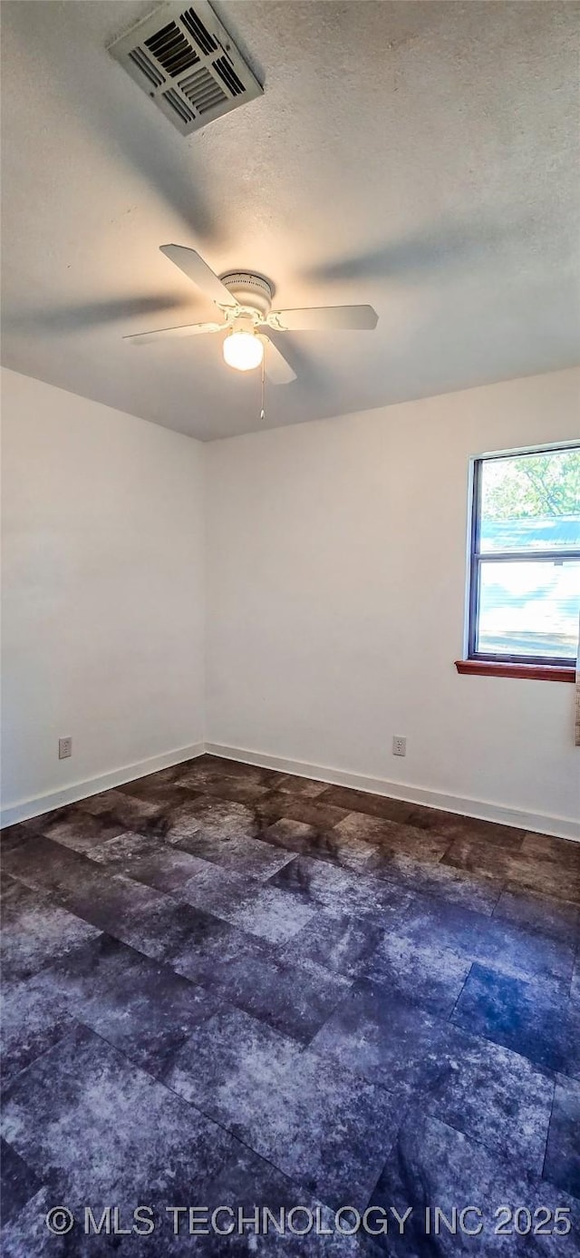 empty room featuring ceiling fan and a textured ceiling