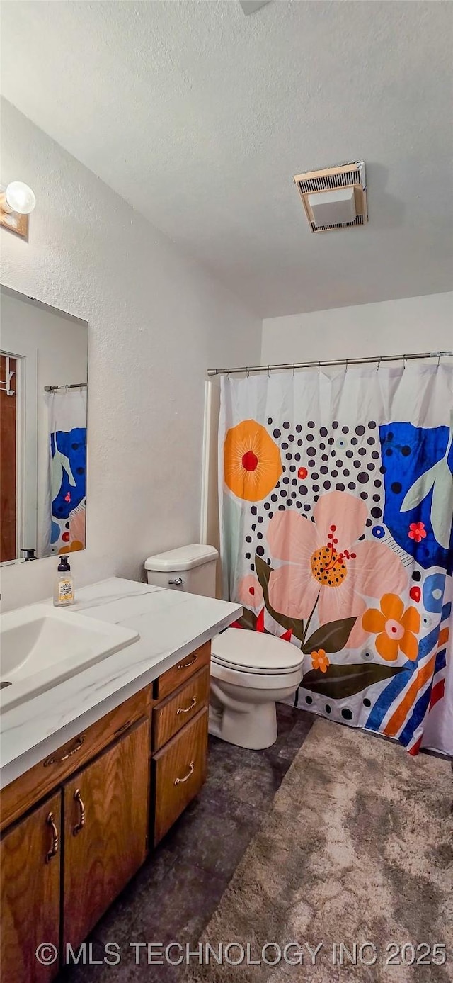 bathroom featuring vanity, toilet, and a textured ceiling