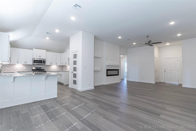 kitchen featuring stainless steel appliances, light stone countertops, sink, and white cabinets