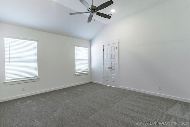 unfurnished room with ceiling fan, vaulted ceiling, and dark colored carpet