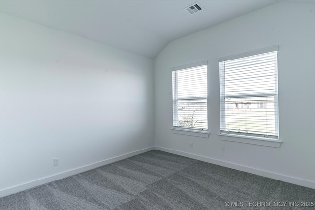 carpeted spare room with vaulted ceiling