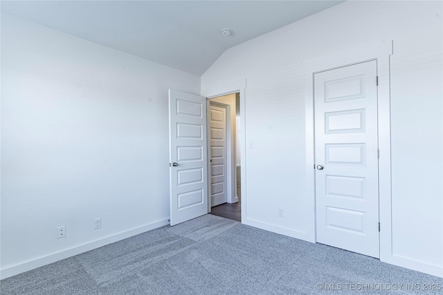 unfurnished bedroom with lofted ceiling and carpet floors