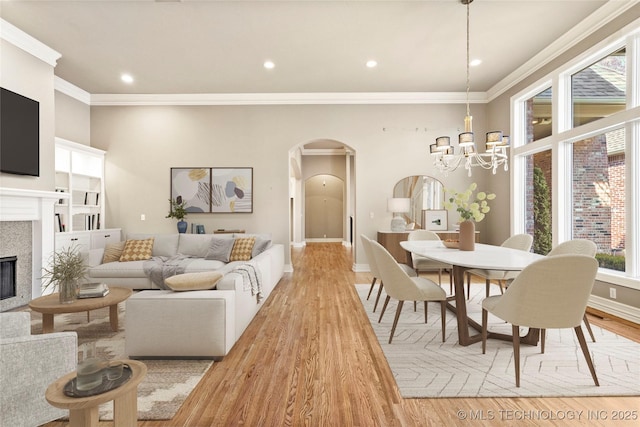 dining area with ornamental molding, a notable chandelier, and light wood-type flooring