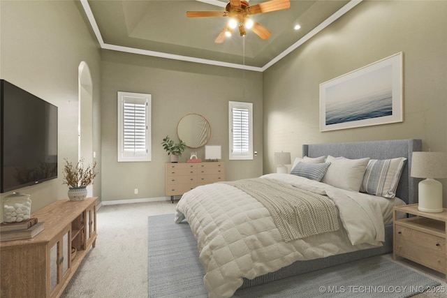 carpeted bedroom featuring a tray ceiling and ceiling fan