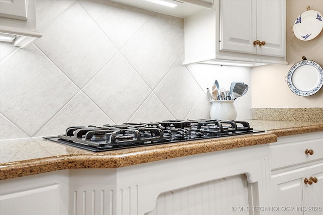 kitchen featuring white cabinetry, decorative backsplash, and black gas cooktop