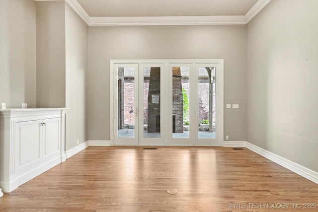 empty room with crown molding and light hardwood / wood-style flooring