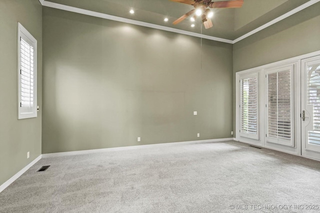 carpeted spare room with crown molding, ceiling fan, and a healthy amount of sunlight