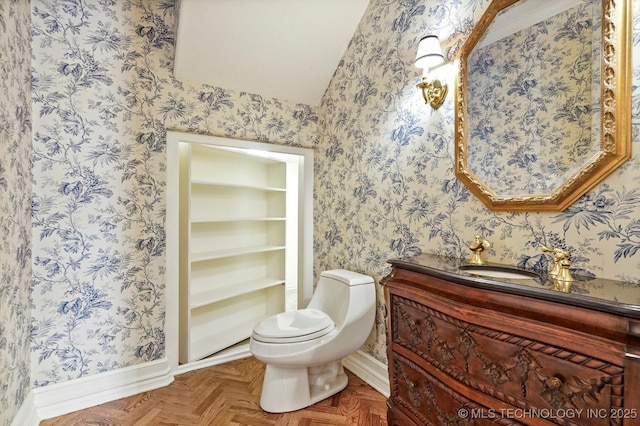 bathroom featuring vanity, parquet flooring, and toilet