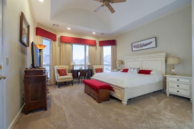 carpeted bedroom featuring crown molding, a tray ceiling, vaulted ceiling, and ceiling fan