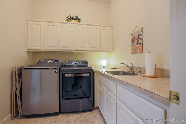 clothes washing area featuring cabinets, sink, and independent washer and dryer