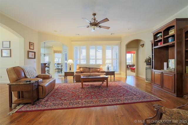 living room featuring a wealth of natural light, ornamental molding, hardwood / wood-style floors, and ceiling fan