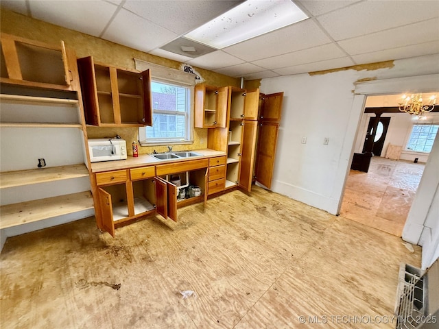 kitchen with sink, a paneled ceiling, and a chandelier