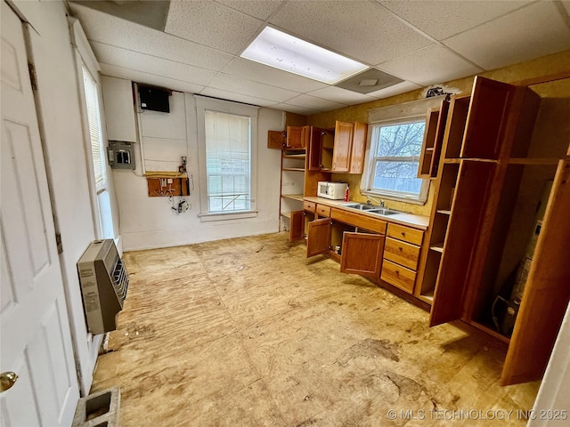 office space featuring a paneled ceiling, sink, and heating unit