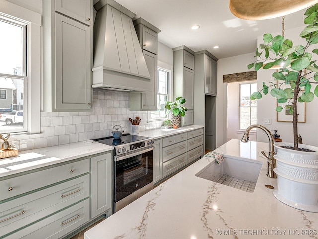 kitchen with sink, premium range hood, gray cabinetry, backsplash, and stainless steel electric range oven