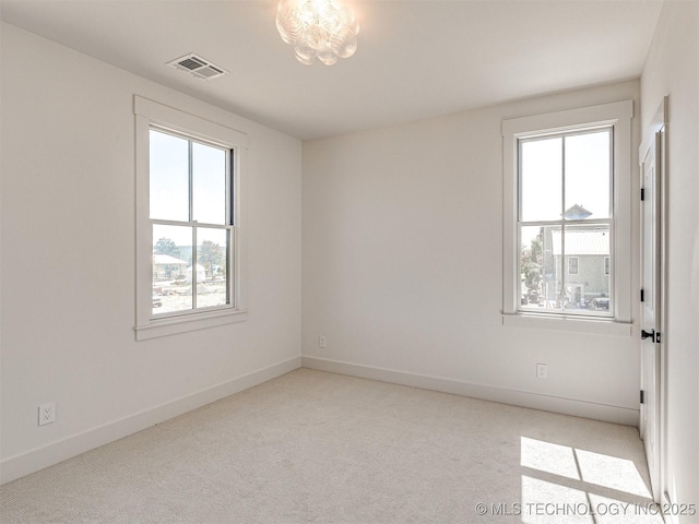 spare room featuring light carpet and a wealth of natural light