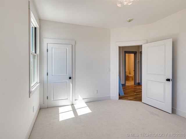 unfurnished bedroom with multiple windows and light colored carpet