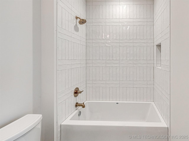 bathroom with toilet and tiled shower / bath
