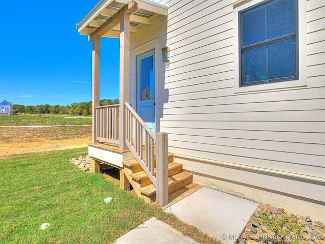 view of exterior entry with a yard