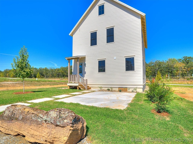 rear view of house featuring a patio area and a lawn