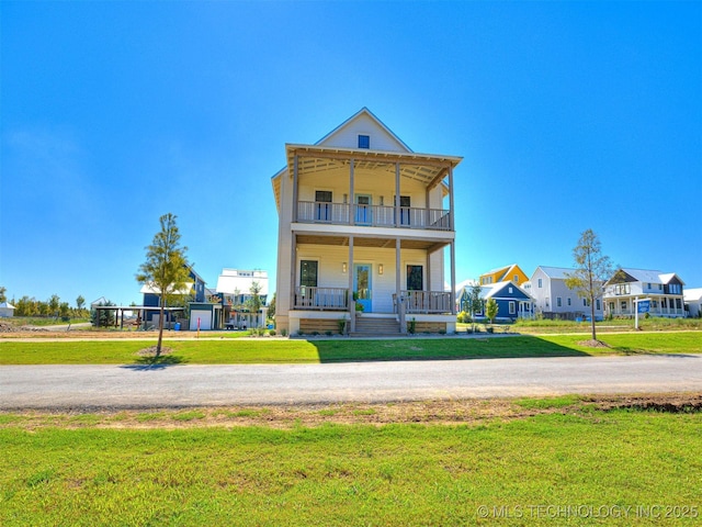 back of house featuring a balcony, a yard, and covered porch
